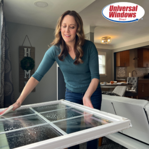 woman with window pan tilted in and wiping it with papertowel