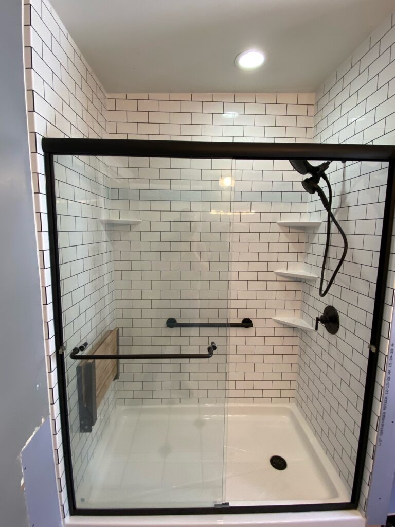 walk-in shower with subway tile pattern and matte balck fixtures