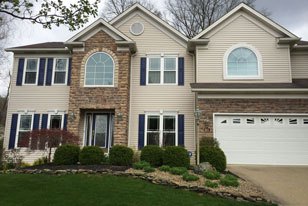The exterior view of a home with siding and brick.