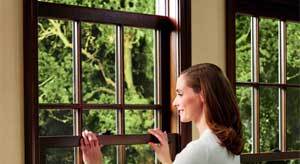 A woman opens her double hung window.