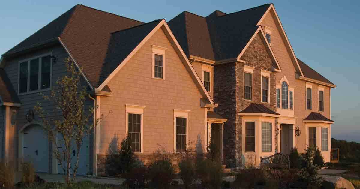 The full exterior of a large house during sunset.