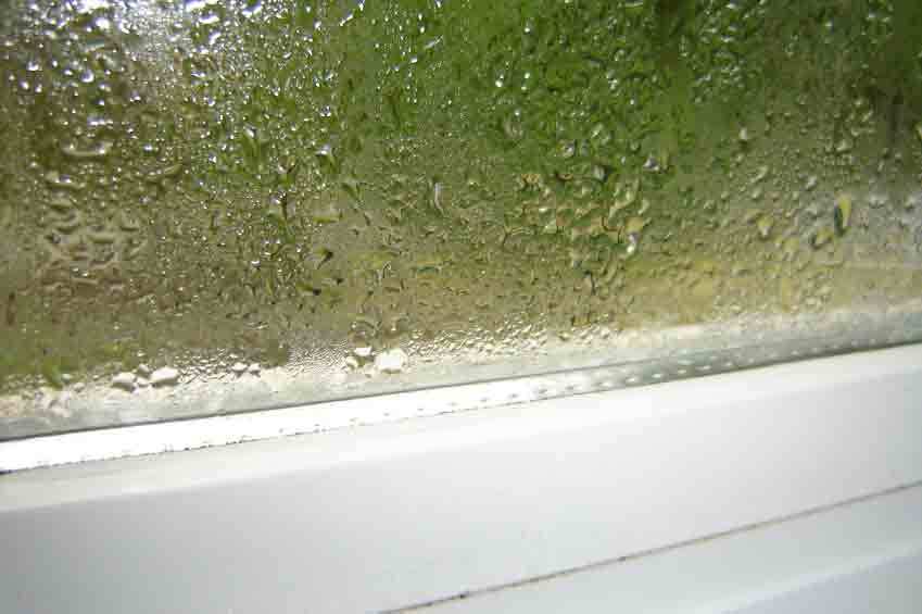 A close up of a window pane with condensation on it.