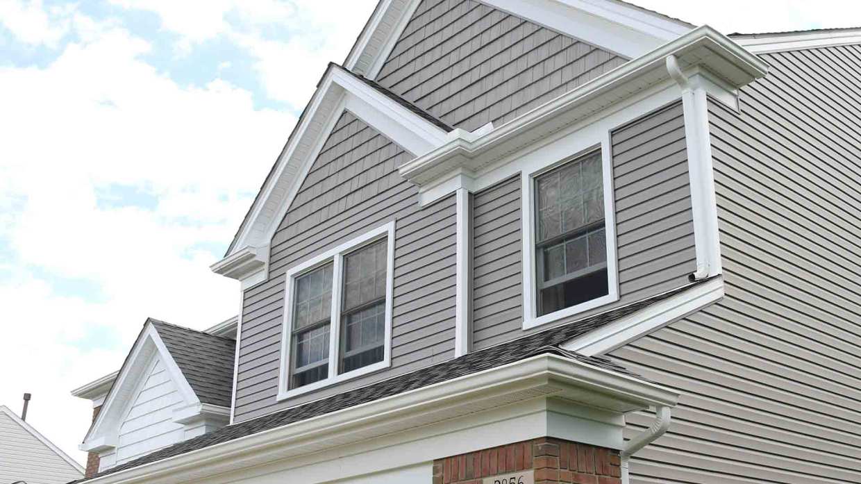 A taupe house with fresh siding replacement.