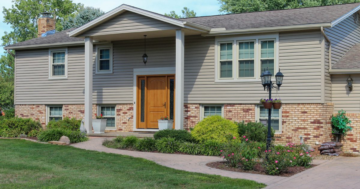 A house with gray siding and brick exterior.