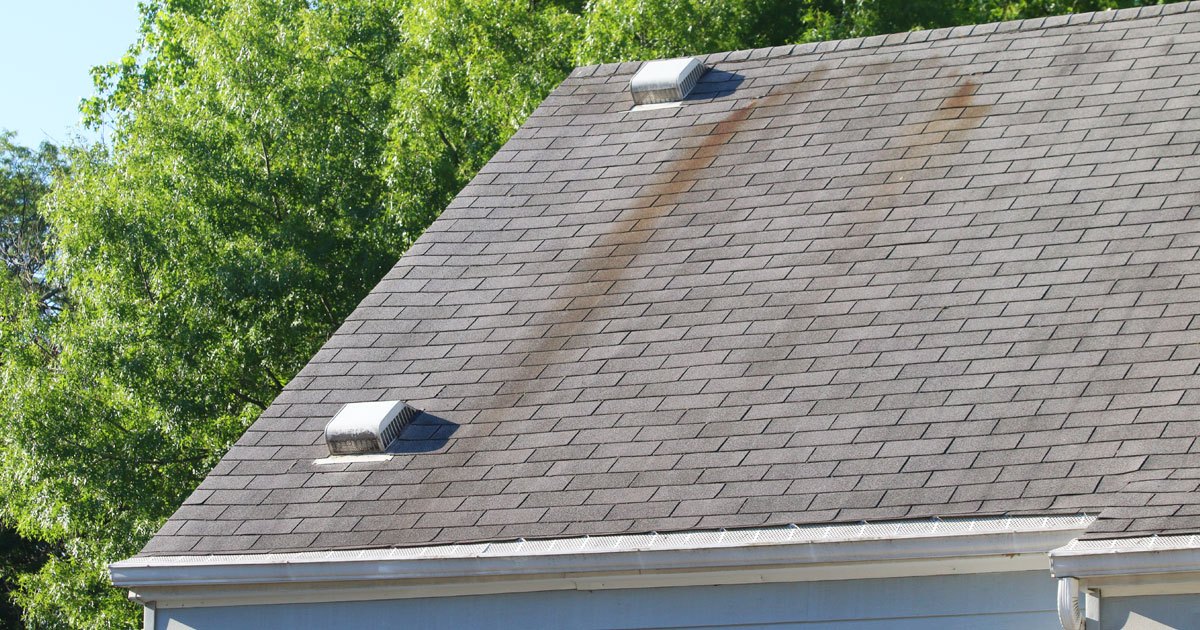 A roof with discoloration on the shingles.