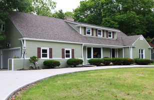 A green house with siding replacement by Universal Windows Direct.