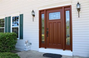 A wood front door with decorative glass.