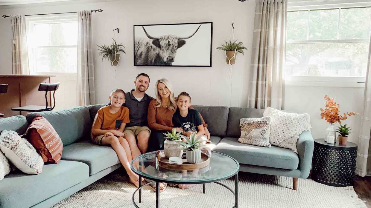 A family smiles in their living room with new windows installed by Universal Windows Direct.