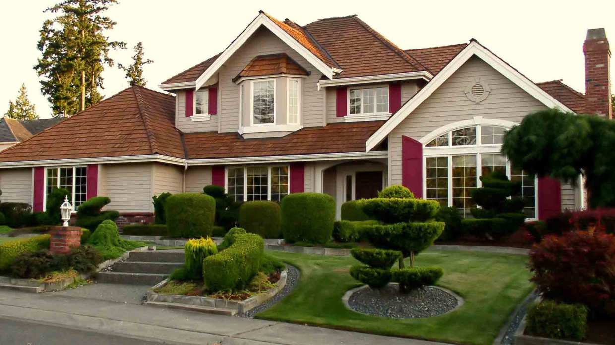 A curb-side perspective of a a house with multiple window styles.