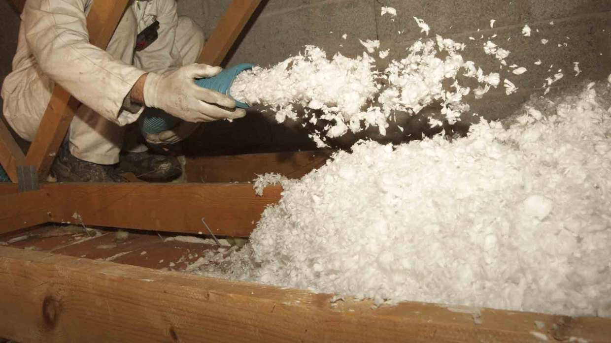 Attic insulation being sprayed by an expert.