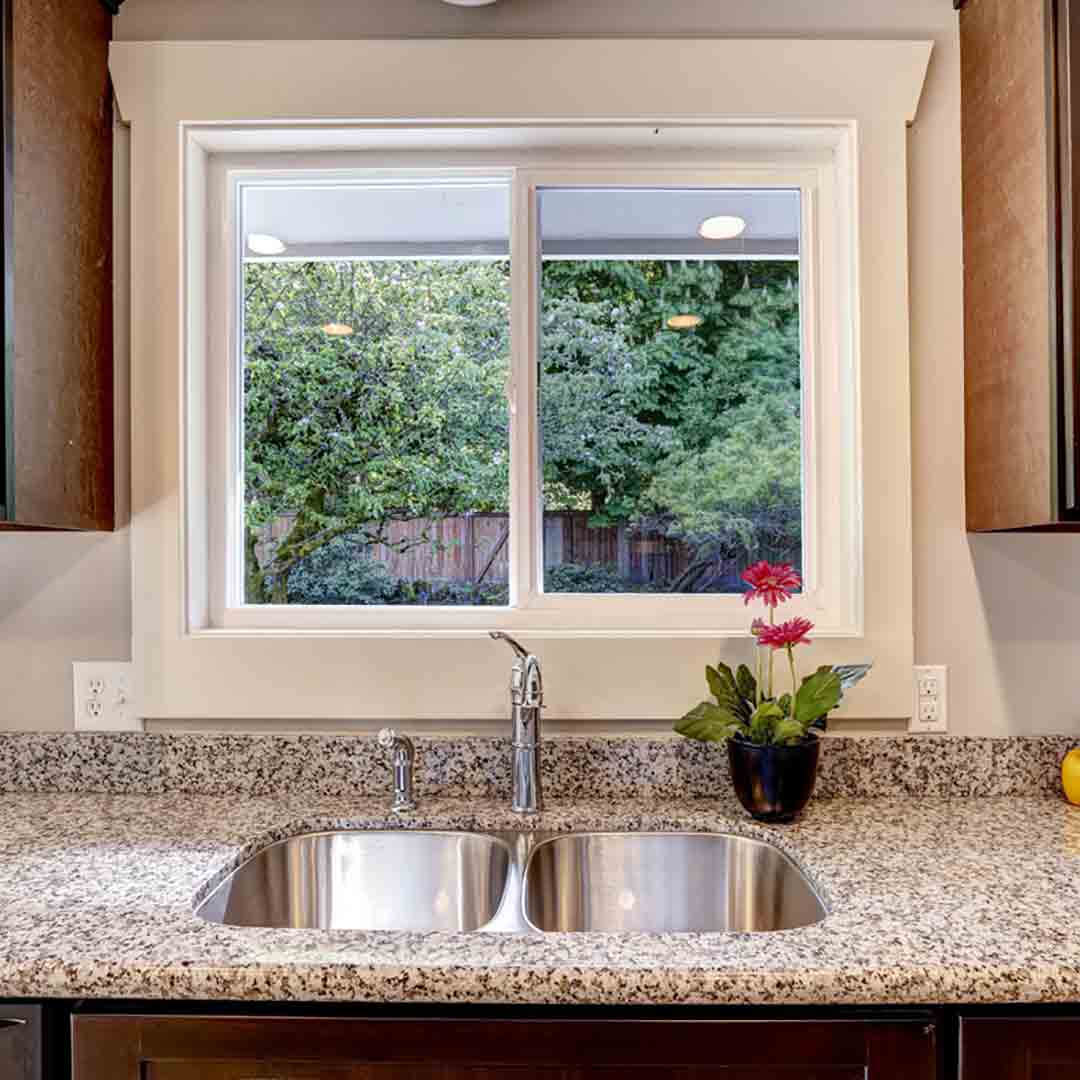 white vinyl slider window above kitchen sink