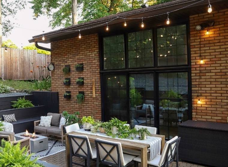 A back patio with dining table and black frame windows and patio door.