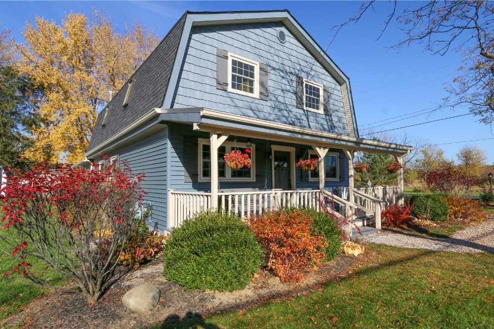A barn-shaped house with blue siding installed by Universal Windows Direct.