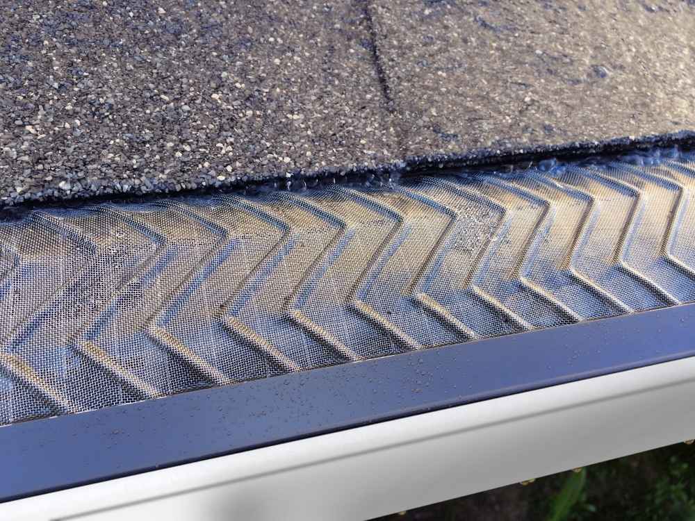 A close up of a gutter guard installed by Universal Windows Direct actively filtering water.