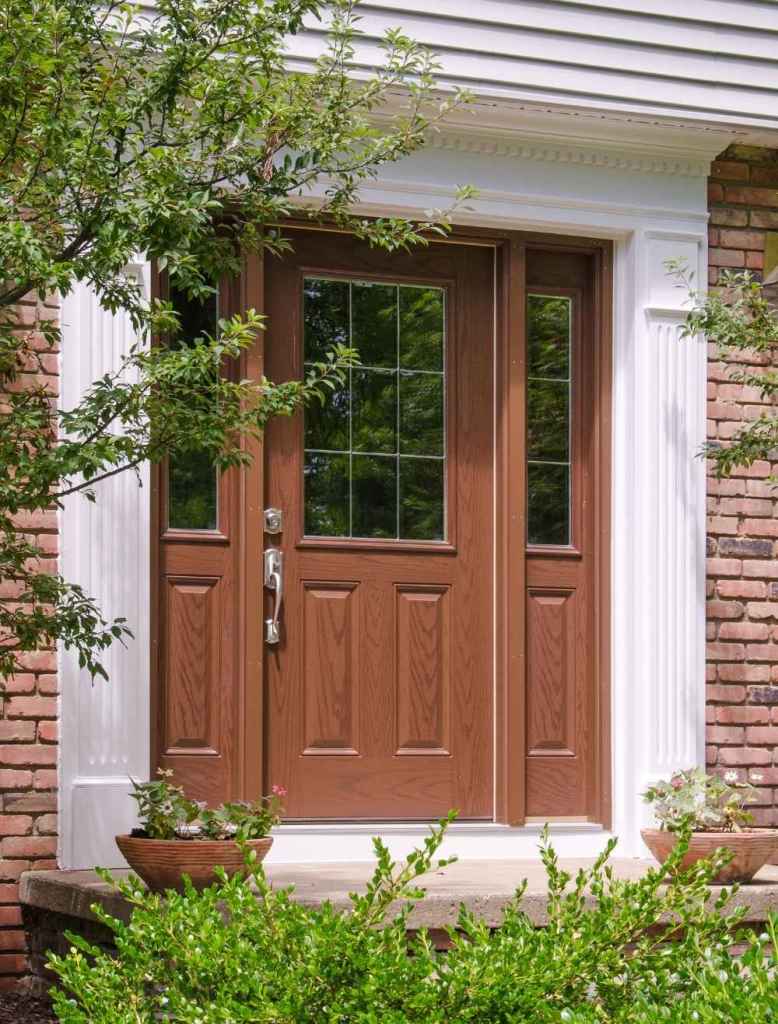 A wood front door with grided glass on the top half installed by Universal Windows Direct.
