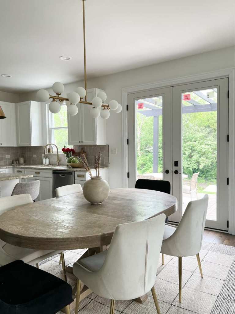 A white, modern dining room and kitchen has a pair of white French doors installed by Universal Windows Direct.