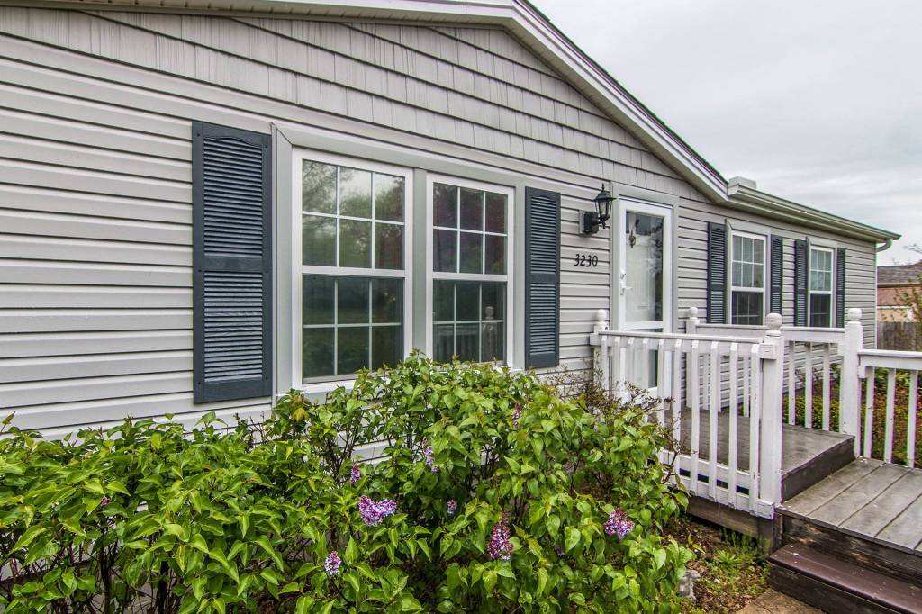 Home with new vinyl siding, shake gables and dark shutters
