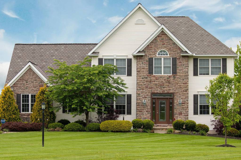 Two-story stone and vinyl home with a new shingle roof