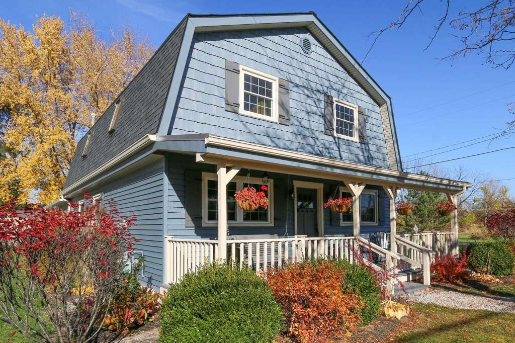 Blue gambrel-roof home with vinyl siding and shake accents