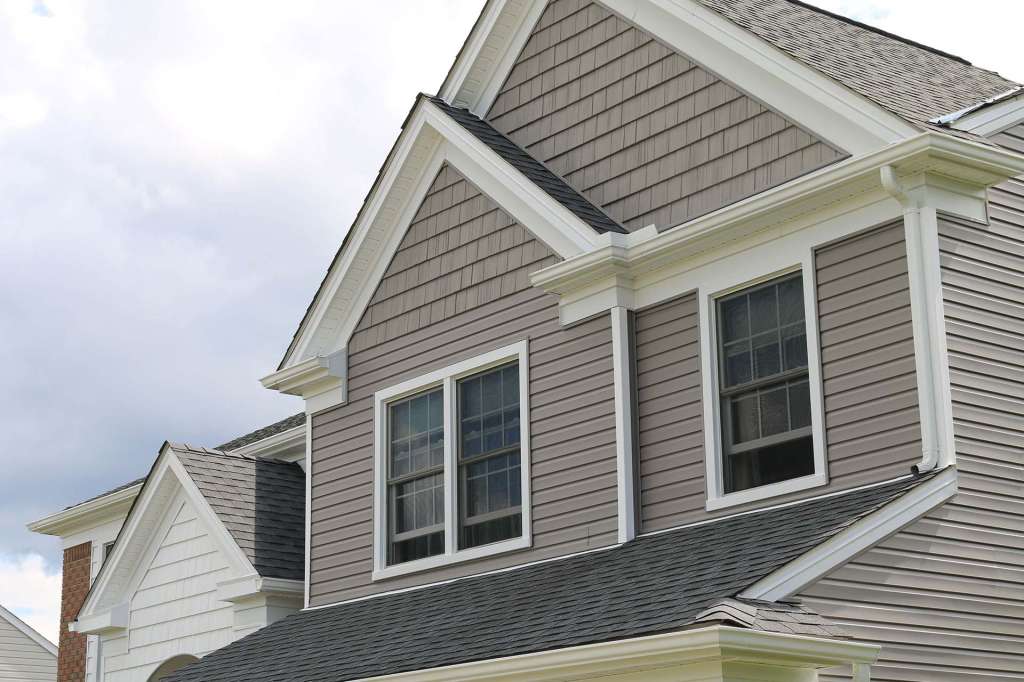 Taupe vinyl siding and shake gables with white trim