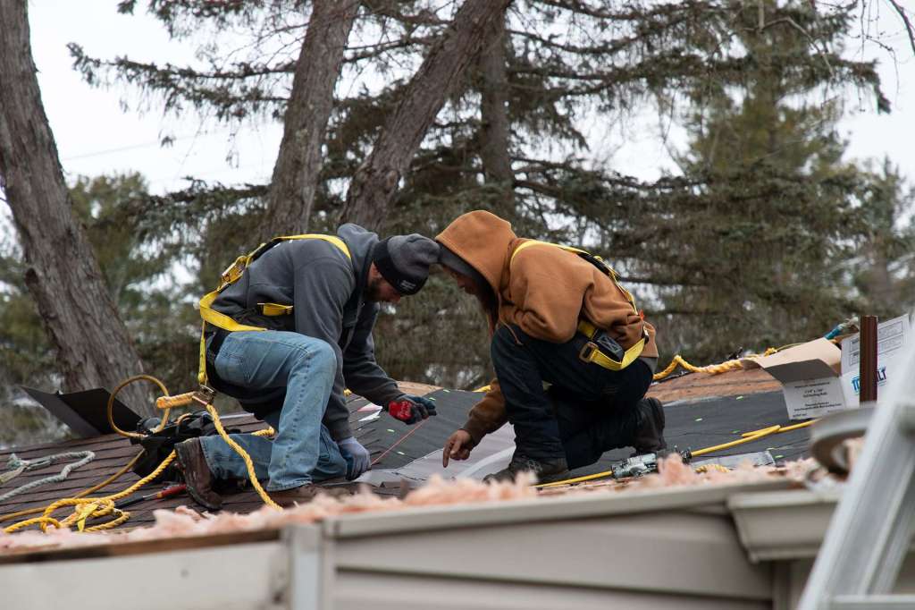 Roofers preparing underlayment on a residential roof