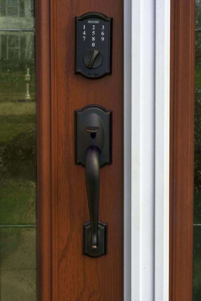 Wood-grain entry door with keypad deadbolt and oil-rubbed bronze handleset