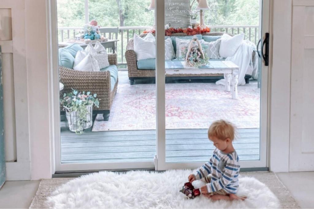 A little boy plays on a rug in front of a glass sliding patio door installed by Universal Windows Direct.