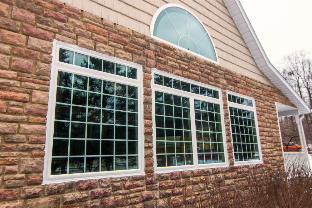 White, grided, casement windows on the side of a house. Installed by Universal Windows Direct.