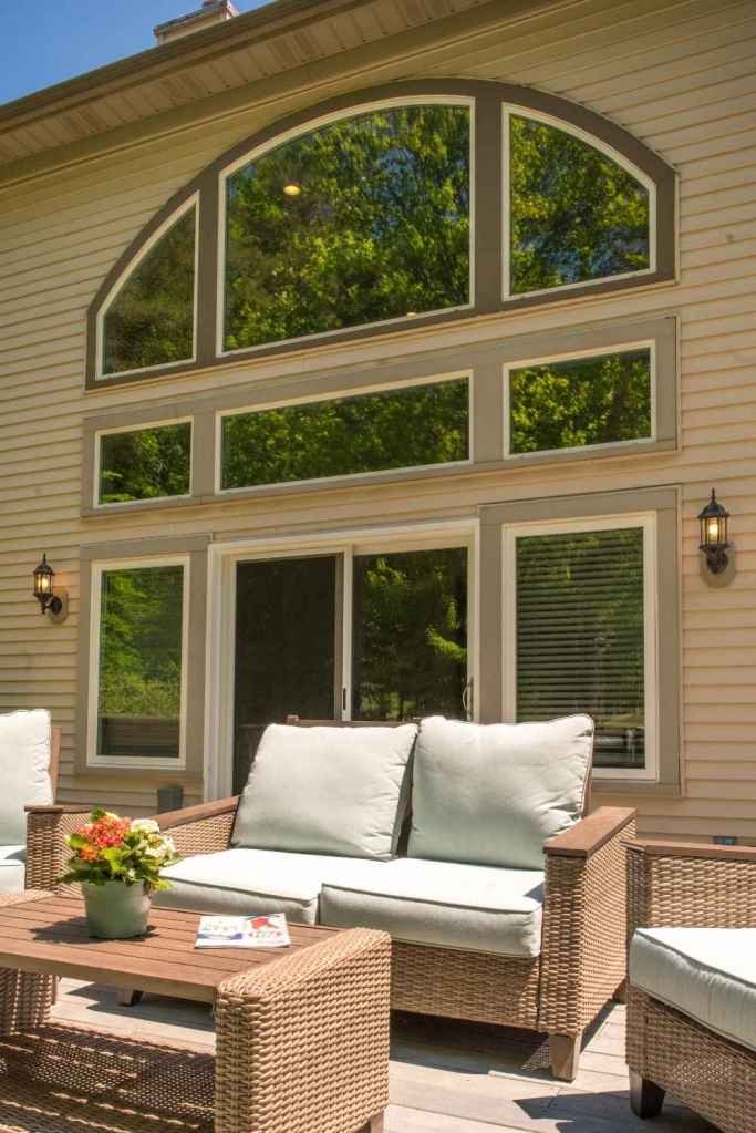 A patio door surrounded by custom shape and size windows overlooking a back patio. Windows and doors installed by Universal Windows Direct.