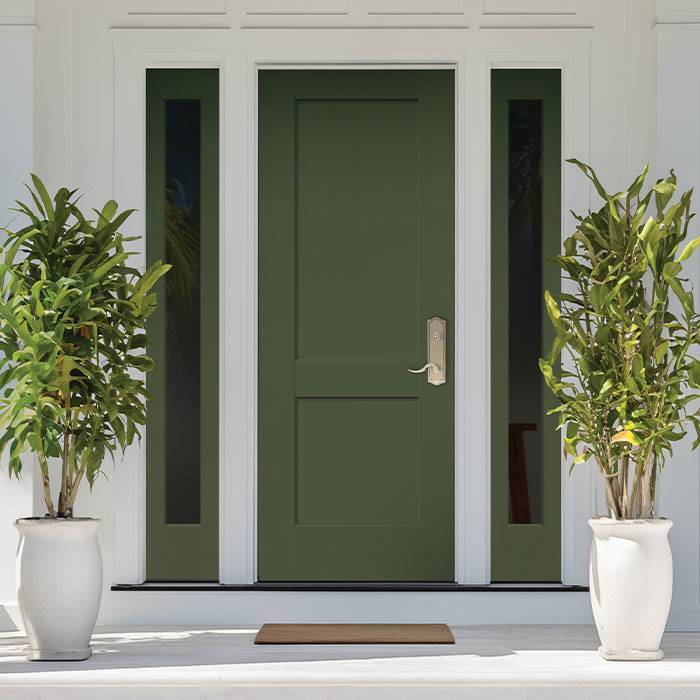 Green entry door with sidelights on a white front porch