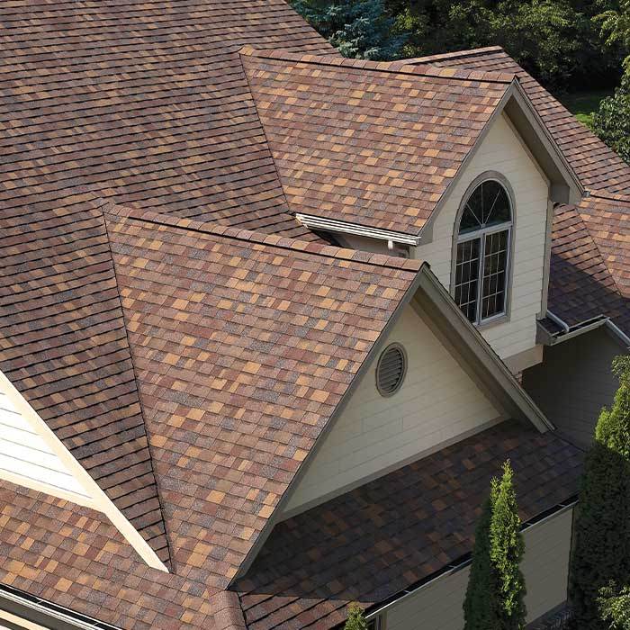 Multi-gabled roof covered in blended brown architectural shingles