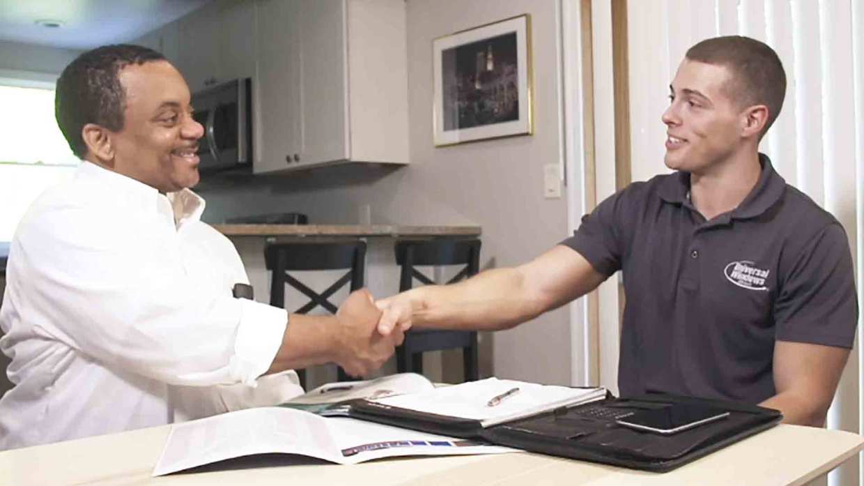 A Universal Windows Direct expert shakes hands with a homeowner.