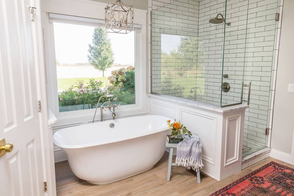 Bathroom with a freestanding tub beside a picture window