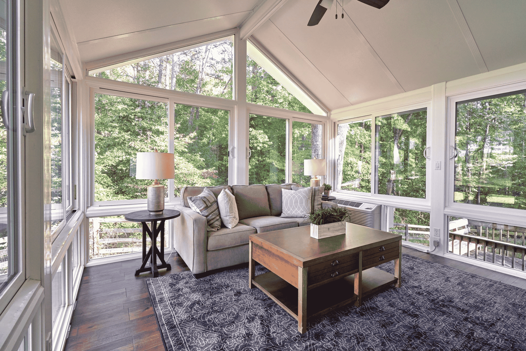 Interior shot of a sunroom with large windows.