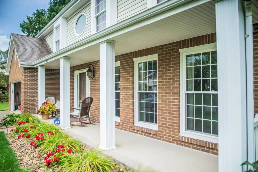 Brick front porch with new white double-hung windows with grids